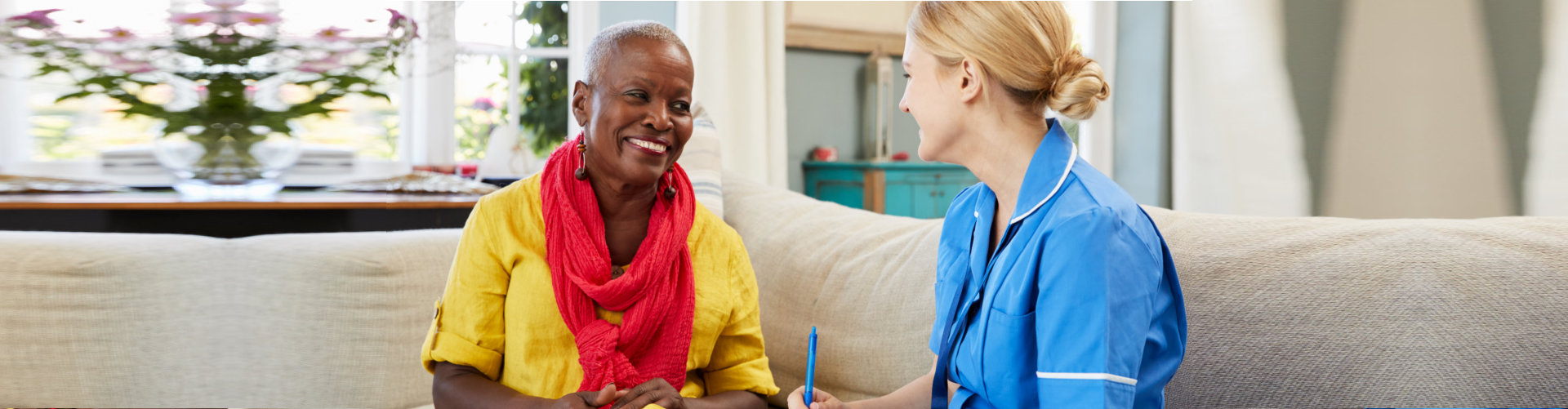 happy senior woman and caregiver talking